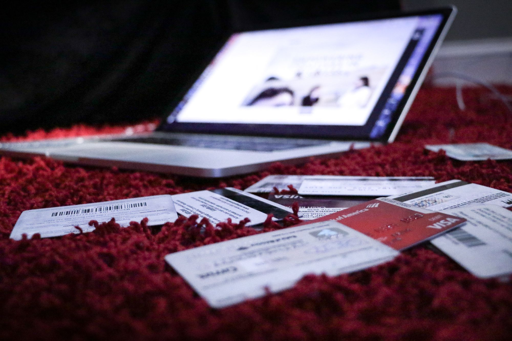 ordinateur portable posé sur un tapis et entouré de plusieurs carte de crédit et de fidélité - blog.troov.com
